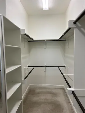 a view of walk in closet with empty racks