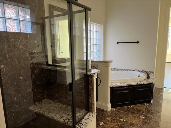 a bathroom with a granite countertop sink a mirror and shower
