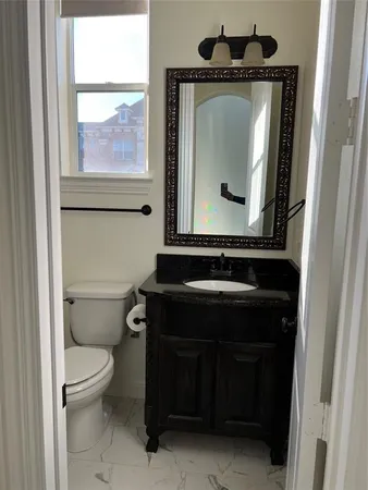 a bathroom with a toilet sink and mirror