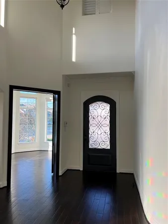 an empty room with wooden floor a ceiling fan and a window