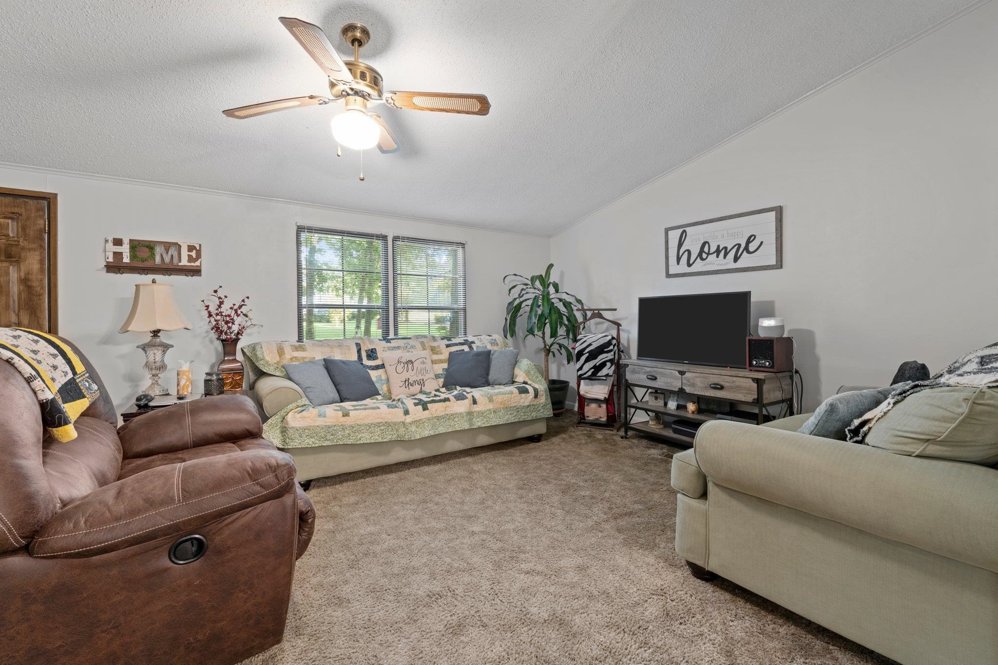 8029 Lockleair Road Zebulon, NC 27597 - Photo 21 of 26 Living room with cathedral and double windows makes this area spacious and open. Living room flows to dining and kitchen. No wasted space in this home. Living Room