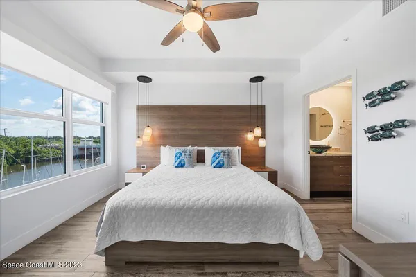 a bedroom with a large bed and a chandelier