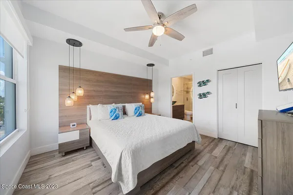 a spacious bedroom with a bed and a flat screen tv