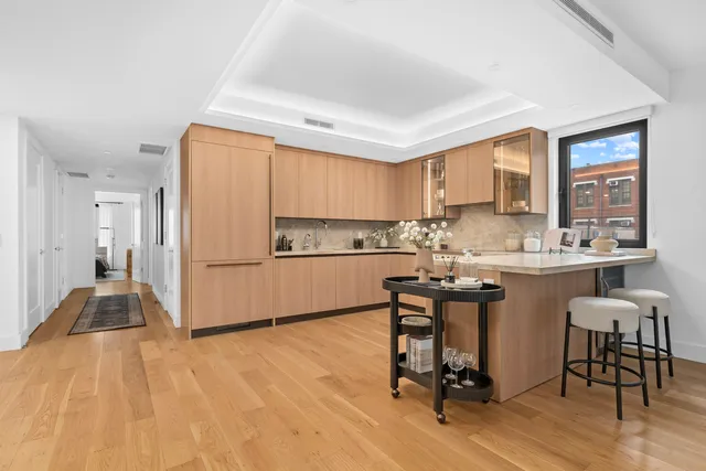 a view of a white wall with white cabinets and refrigerator