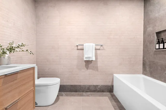 a bedroom with a bed a mirror and lamp