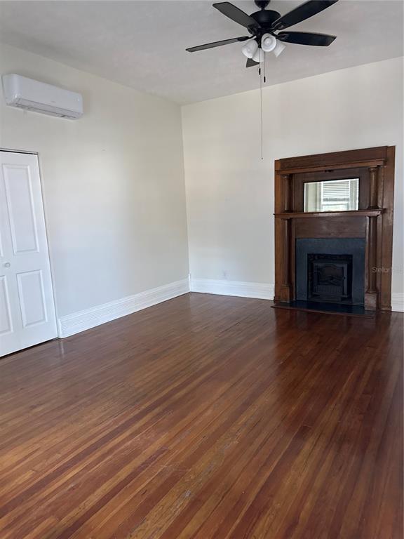 32 Southeast 9th Avenue, Unit 1B Ocala, FL 34471 - Photo 2 of 7 a view of an empty room with wooden floor fireplace and a window