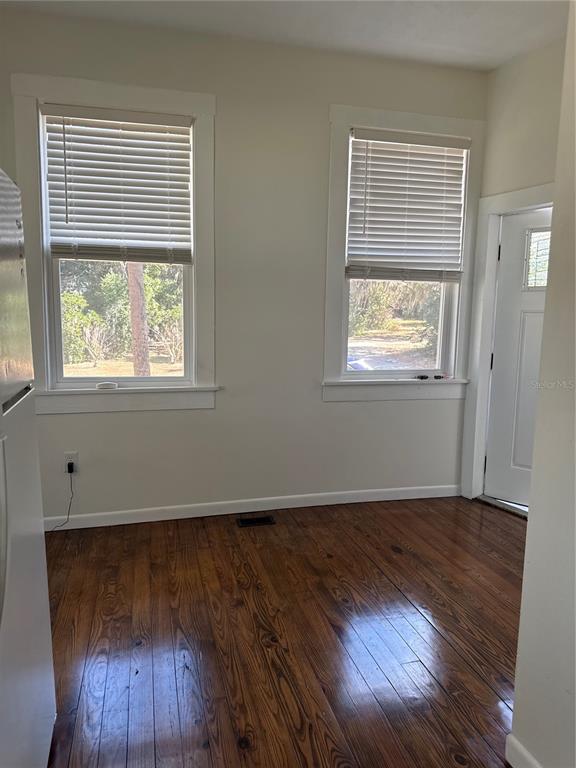 32 Southeast 9th Avenue, Unit 1B Ocala, FL 34471 - Photo 3 of 7 an empty room with wooden floor and windows