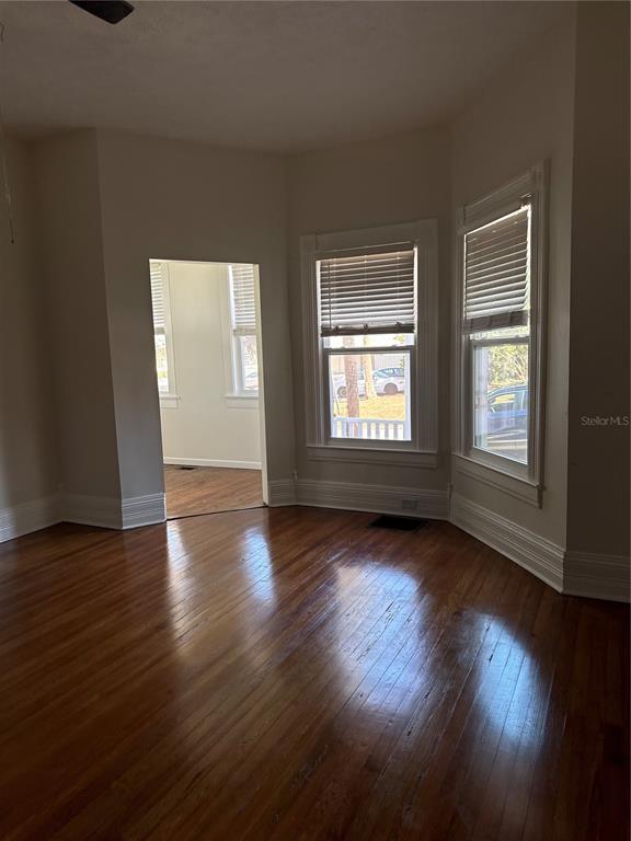 32 Southeast 9th Avenue, Unit 1B Ocala, FL 34471 - Photo 4 of 7 an empty room with wooden floor and windows