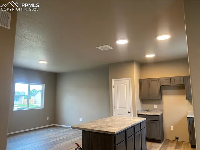 a kitchen with a sink cabinets and wooden floor