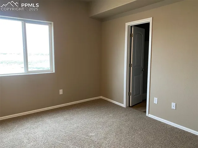 an empty room with windows and closet