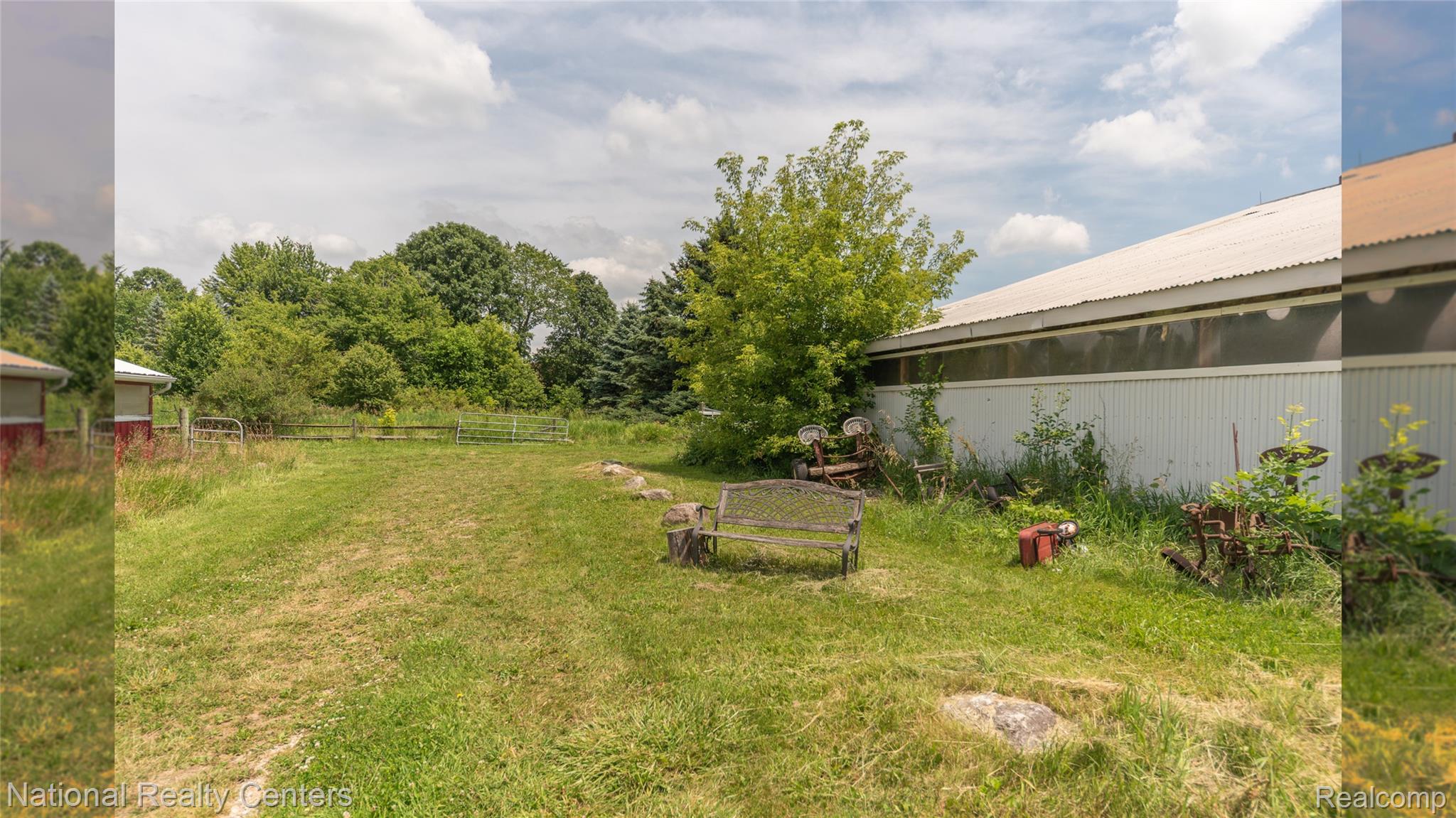 58191 8 Mile Road Northville, MI 48167 - Photo 20 of 57 Expansive grassy area with abundant mature trees and a substantial outbuilding featuring a corrugated metal roof