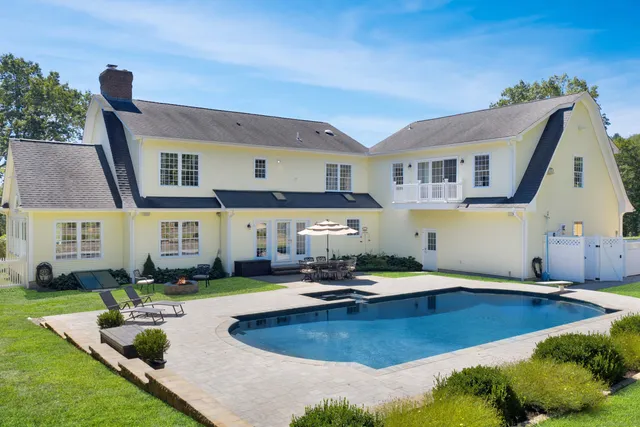 a view of a house with swimming pool and furniture
