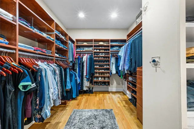 a view of walk in closet with clothes and shoes