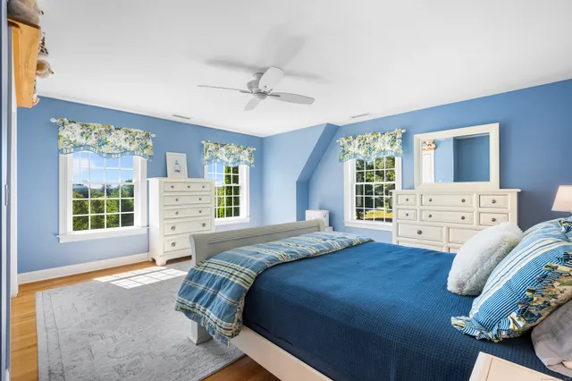 a spacious bedroom with a bed and wooden floor