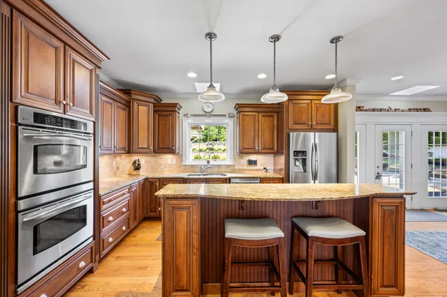 a kitchen with stainless steel appliances granite countertop a stove a sink and a refrigerator