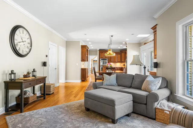 a living room with furniture a clock on wall and a mirror