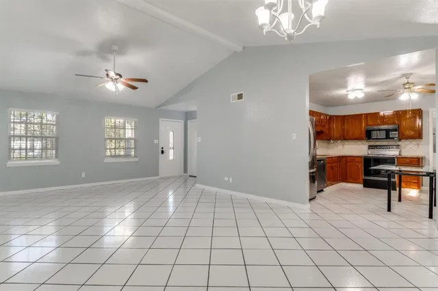 a view of an empty room and kitchen view