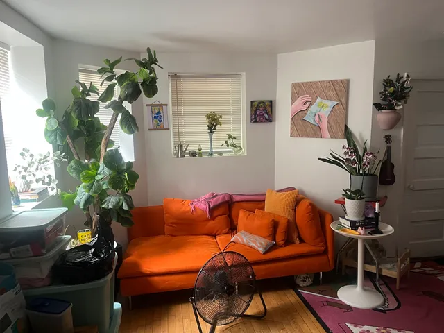 a blue couch sitting in a living room next to a window