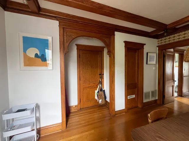 a view of a hallway with wooden floor and closet