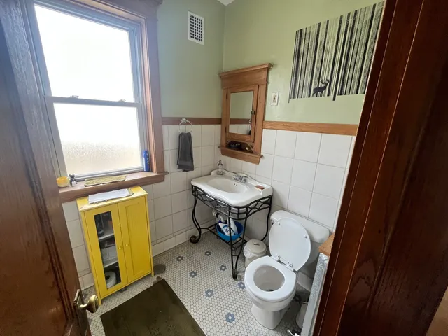 a bathroom with a sink a toilet and a mirror