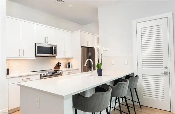 a kitchen with a sink and a stove top oven with wooden floor