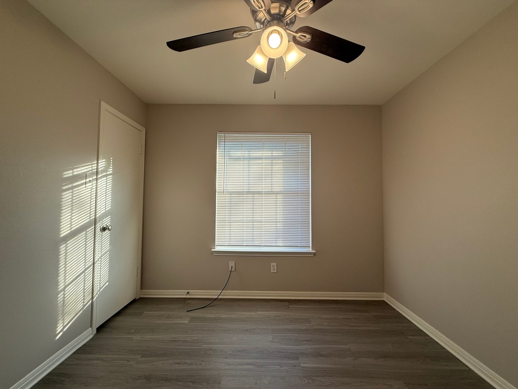 1904 Alex Avenue, Unit A Austin, TX 78728 - Photo 12 of 15 Empty room with dark wood-type flooring and ceiling fan