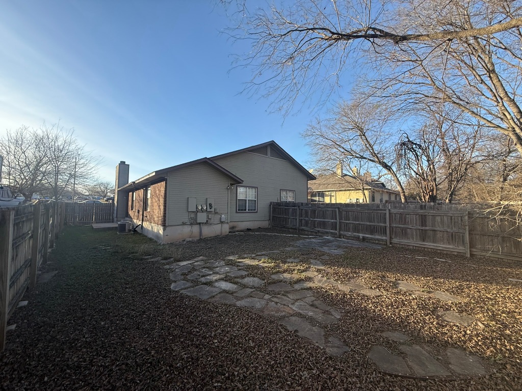 1904 Alex Avenue, Unit A Austin, TX 78728 - Photo 14 of 15 View of property exterior featuring a fenced backyard and a chimney