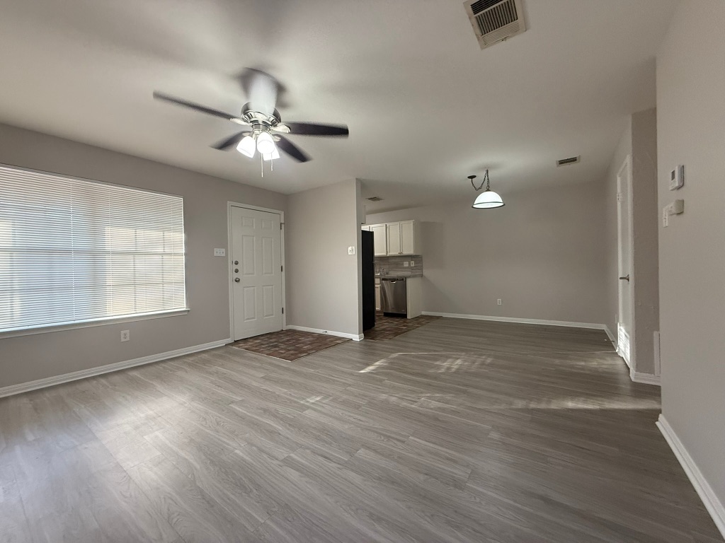 1904 Alex Avenue, Unit A Austin, TX 78728 - Photo 4 of 15 Unfurnished living room with a ceiling fan and dark wood-style flooring