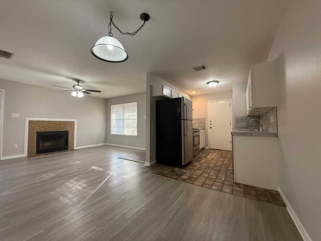 1904 Alex Avenue, Unit A Austin, TX 78728 - Photo 15 of 15 Kitchen with white cabinets, stainless steel appliances, light countertops, open floor plan, and tasteful backsplash