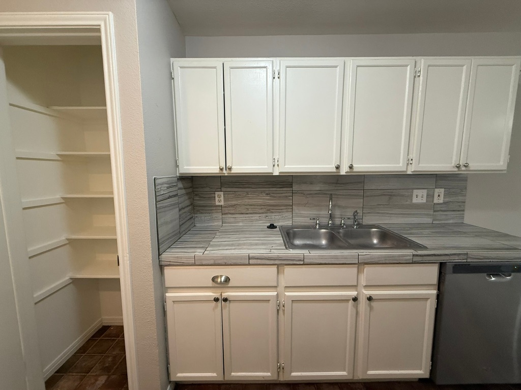 1904 Alex Avenue, Unit A Austin, TX 78728 - Photo 5 of 15 Kitchen featuring tile counters, dishwasher, white cabinetry, and decorative backsplash