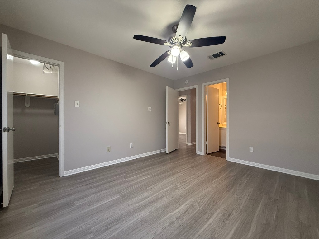 1904 Alex Avenue, Unit A Austin, TX 78728 - Photo 9 of 15 Unfurnished bedroom with a walk in closet, wood finished floors, a ceiling fan, and ensuite bathroom