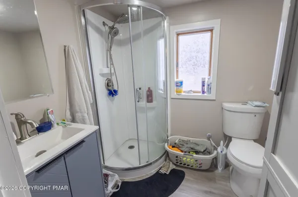 a white toilet sitting next to a bathroom sink and a shower