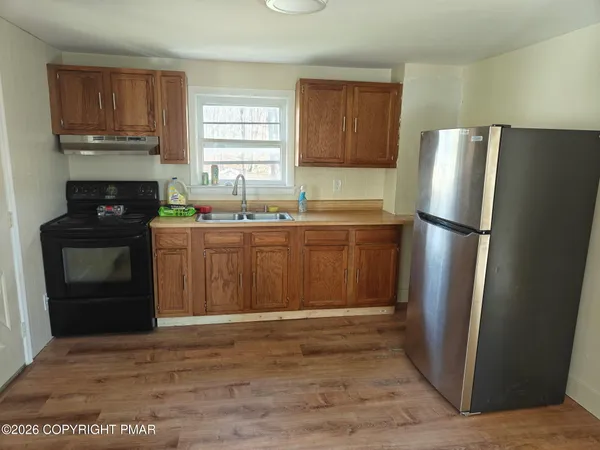 a kitchen with stainless steel appliances granite countertop a refrigerator stove and sink