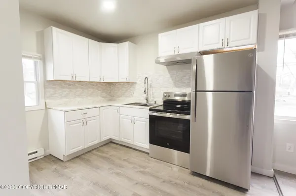 a kitchen with a refrigerator sink and cabinets