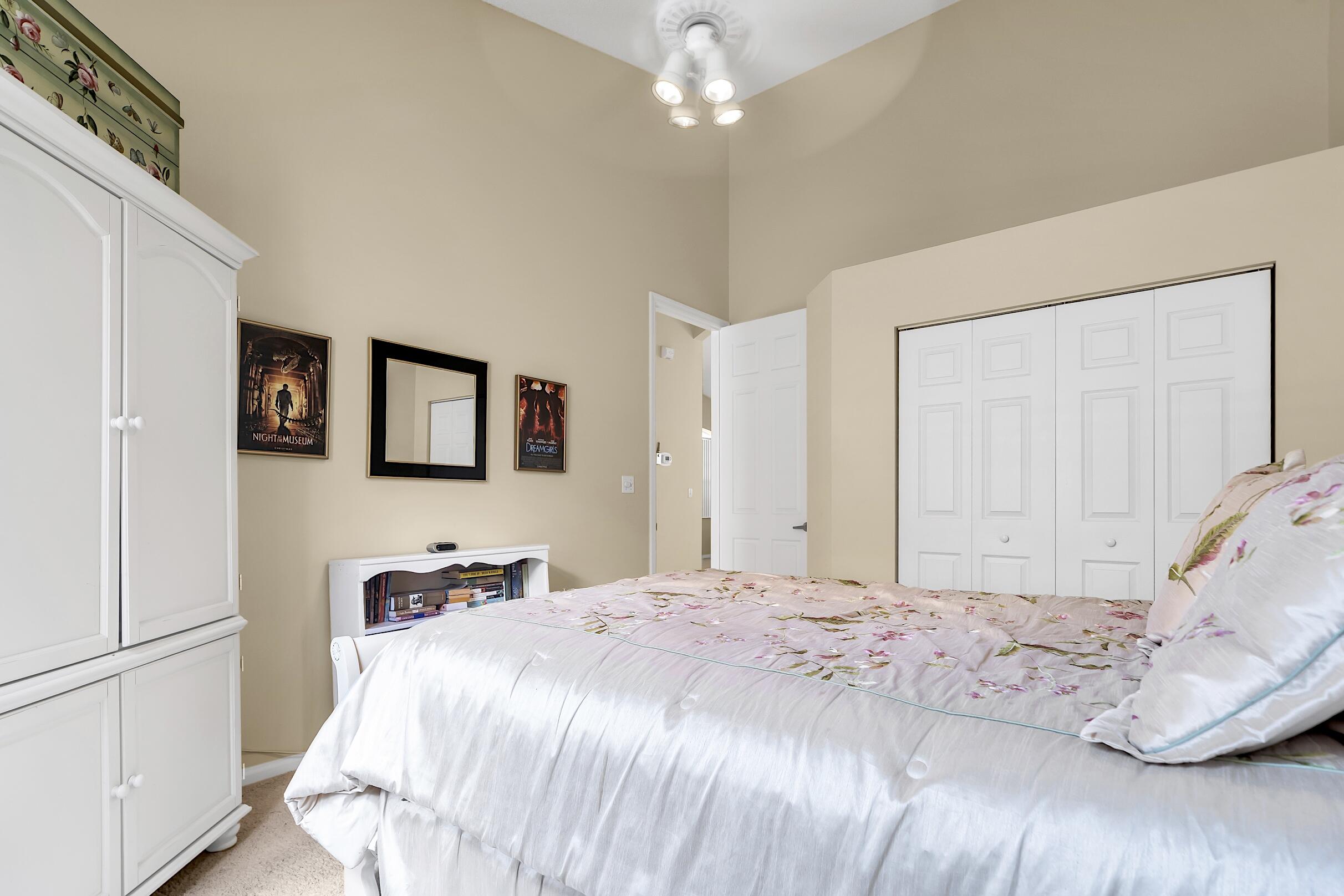 7507 Eagle Point Drive Delray Beach, FL 33446 - Photo 33 of 49 a bedroom with a large bed and a chandelier