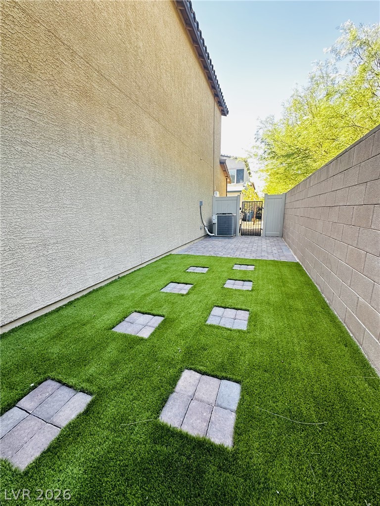 7331 Sunray Point Street North Las Vegas, NV 89084 - Photo 16 of 20 Green turf with stepping stones creates a serene, low-maintenance private yard.