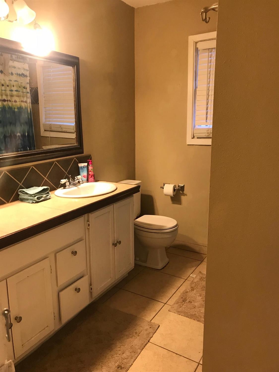 2604 44th Street Lubbock, TX 79413 - Photo 2 of 10 a bathroom with a sink and a mirror