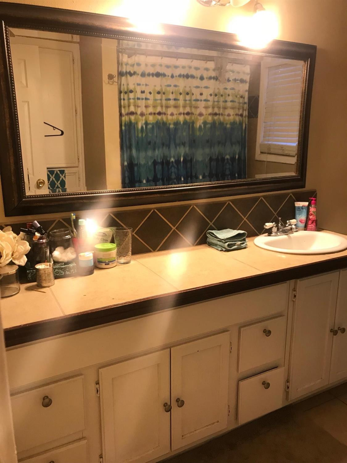 2604 44th Street Lubbock, TX 79413 - Photo 3 of 10 a bathroom with a sink and a mirror