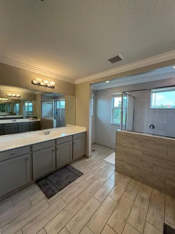 a large bathroom with a large mirror vanity and chandelier