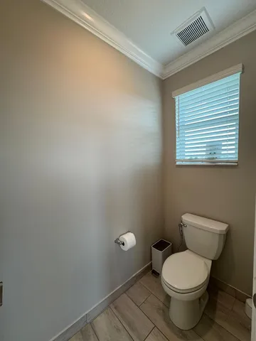 a white toilet sitting next to a bathroom sink and vanity
