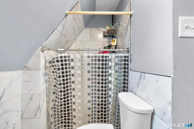 a bathroom with a toilet and a shower curtain