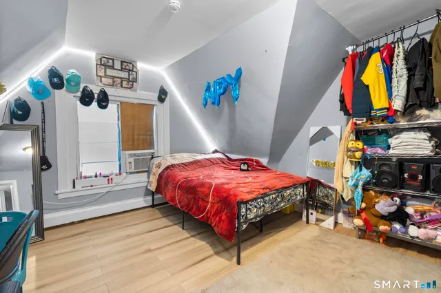 a bedroom with a bed closet and flat tv screen on a dresser