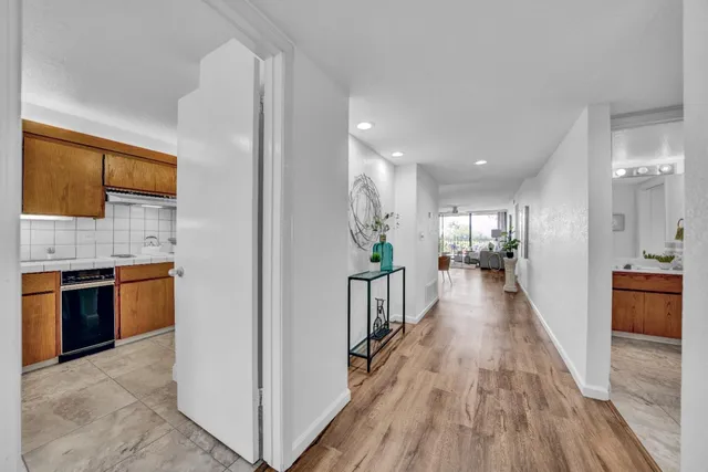 a view of a kitchen with kitchen island wooden floor and stainless steel appliances