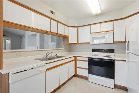 a kitchen with stainless steel appliances a refrigerator sink and white cabinets