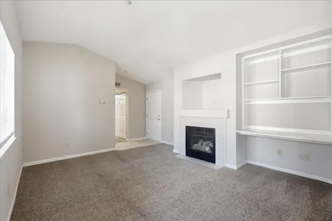 an empty room with a fireplace and cabinet