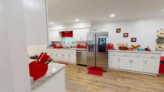 a kitchen with granite countertop a stove top oven and cabinets