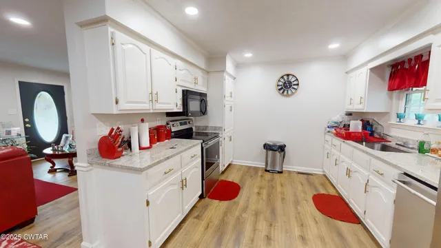 a kitchen with stainless steel appliances kitchen island granite countertop a stove and a microwave