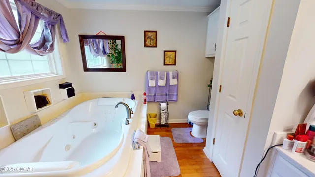 a bedroom with a bed and a flat tv screen on the dresser