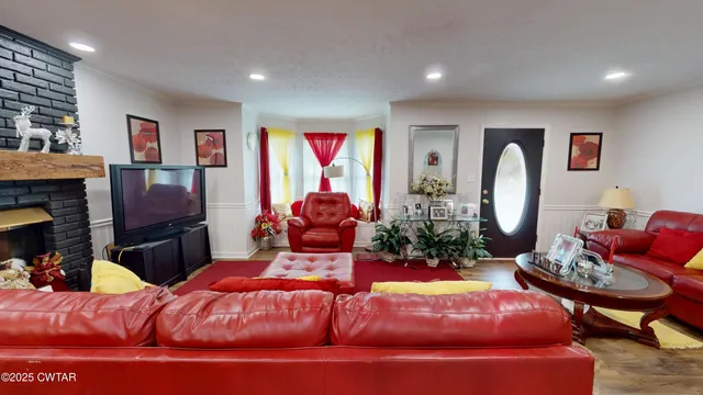 a living room with furniture fireplace and a large window