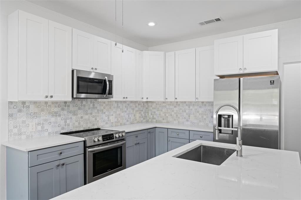 2405 Monroe Street Commerce, TX 75428 - Photo 12 of 31 a kitchen with a sink cabinets and stainless steel appliances